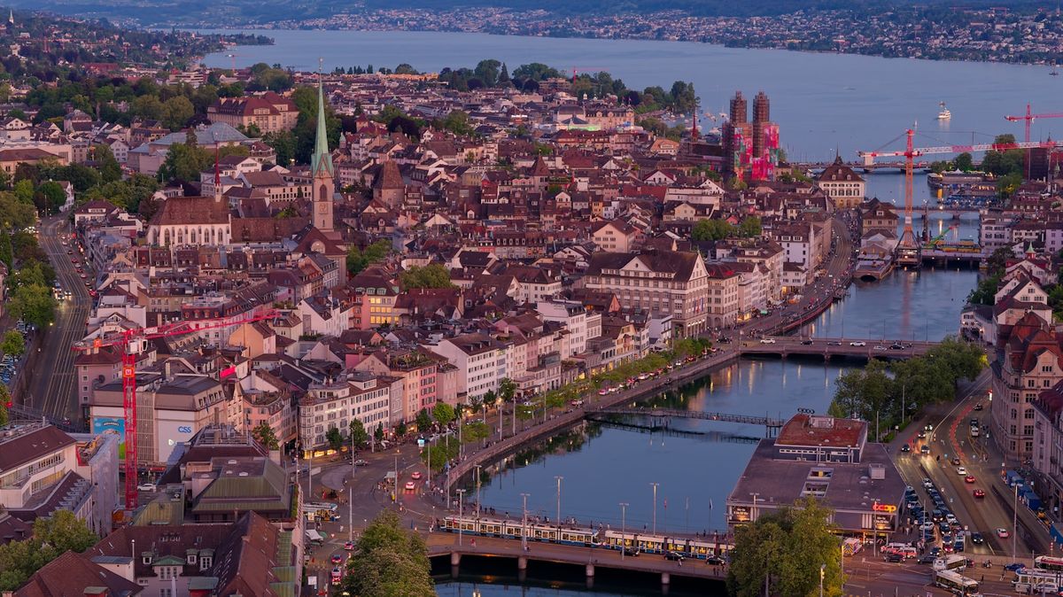 Zurich cityscape with river buildings and lake at dusk