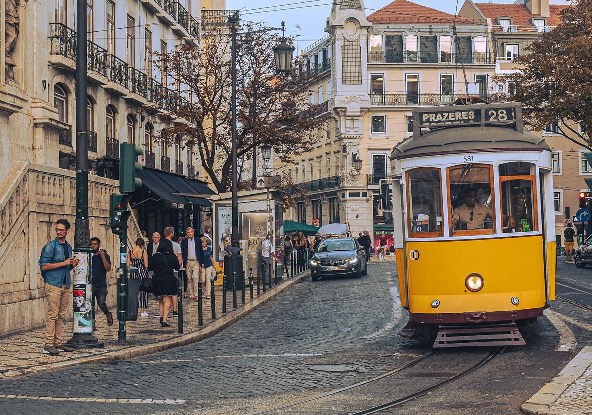 A yellow tram on a street in Lisbon