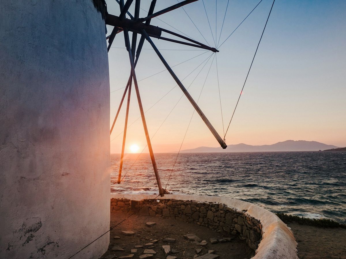 Windmill silhouetted against the sunset over the Aegean Sea