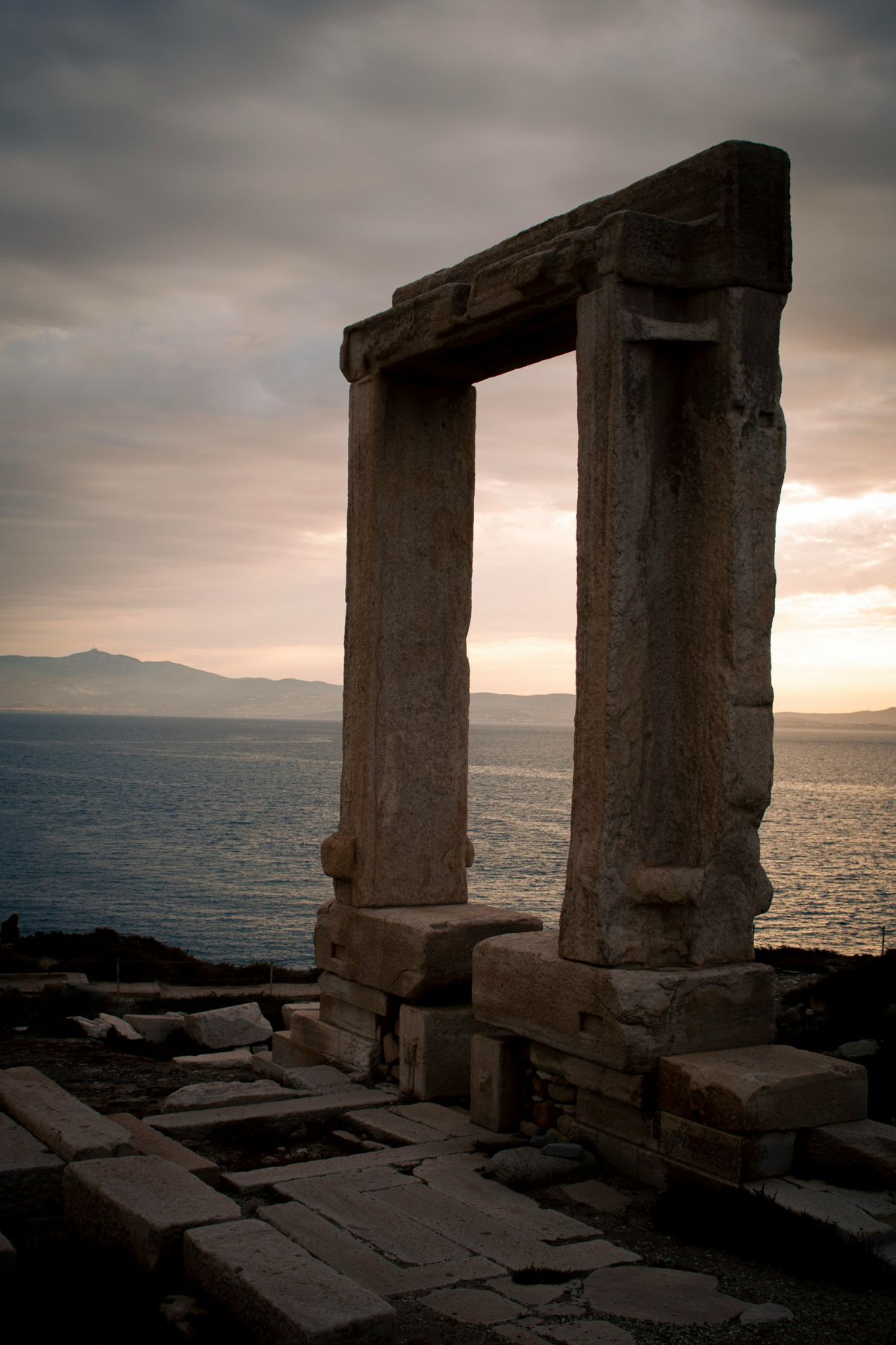 Ancient stone doorway (Portara) overlooking the sea at sunset in Naxos