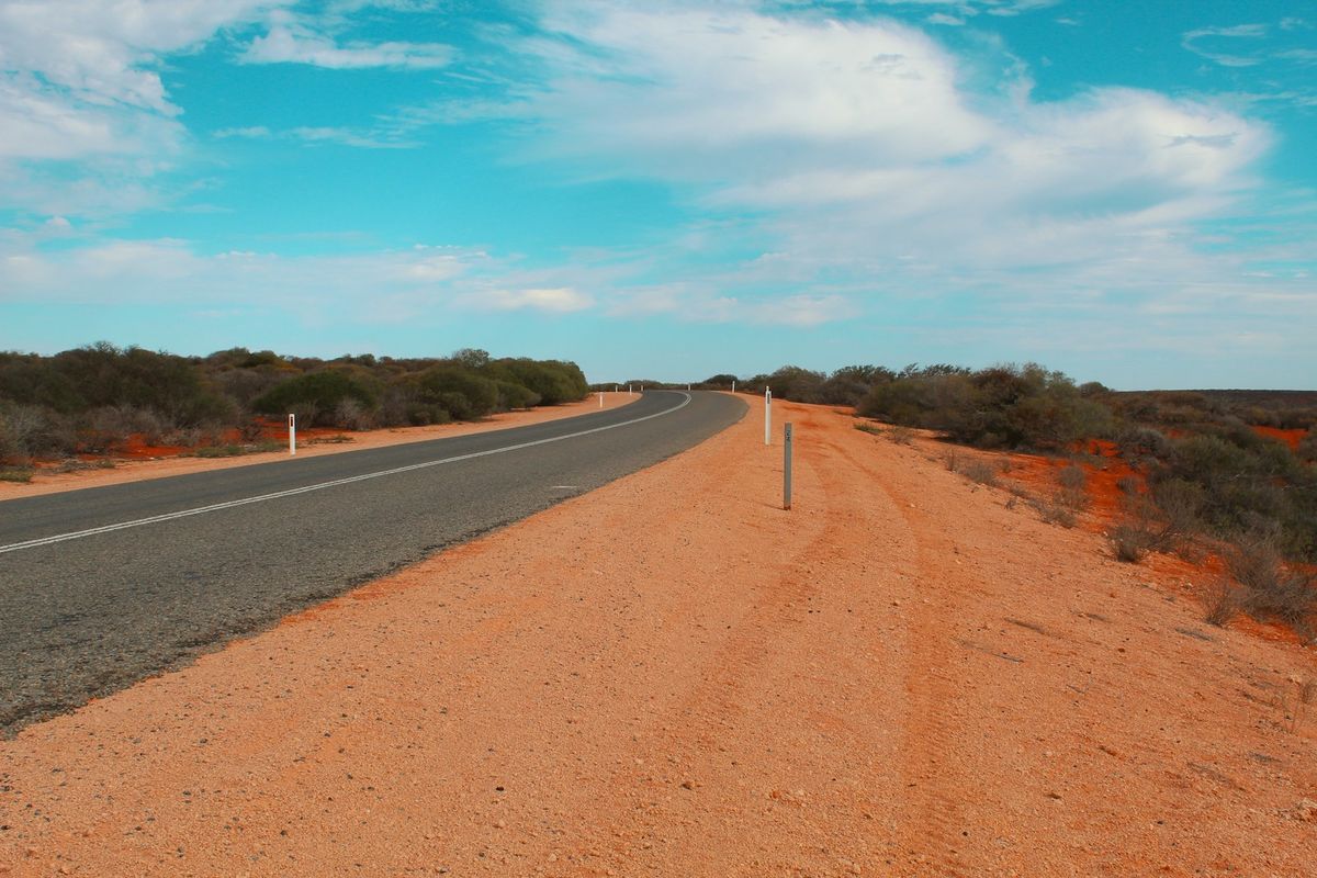 Empty outback road stretching into the Australian desert