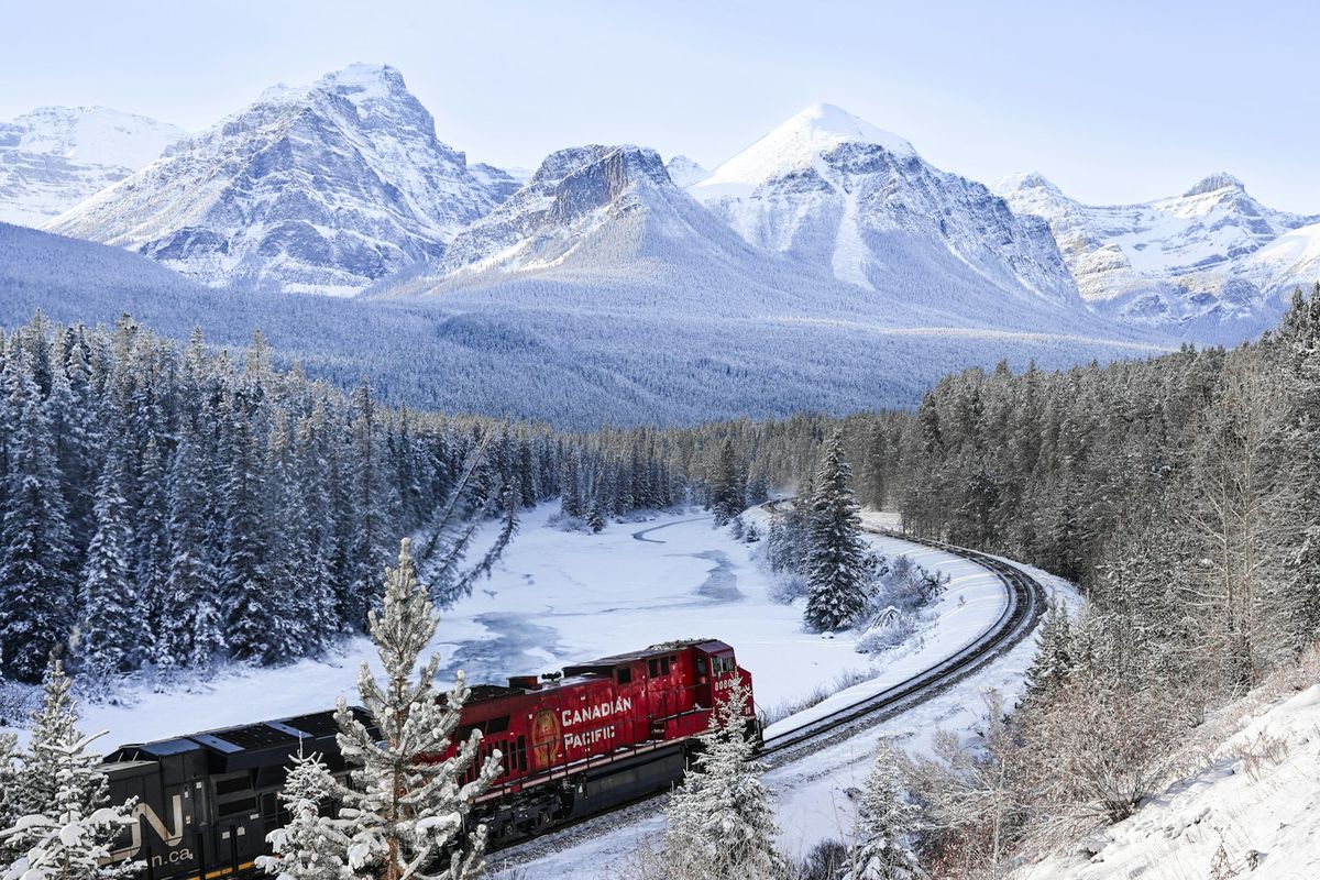 A train traveling through a snow-covered Canadian forest