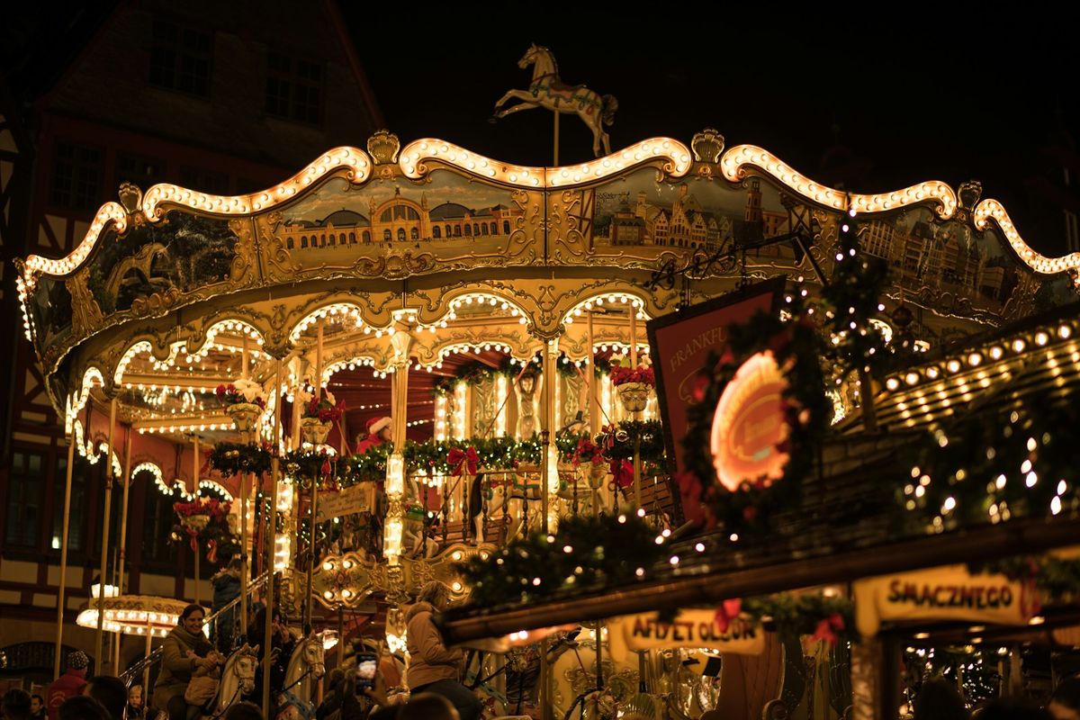 Illuminated carousel at a European Christmas market in the evening