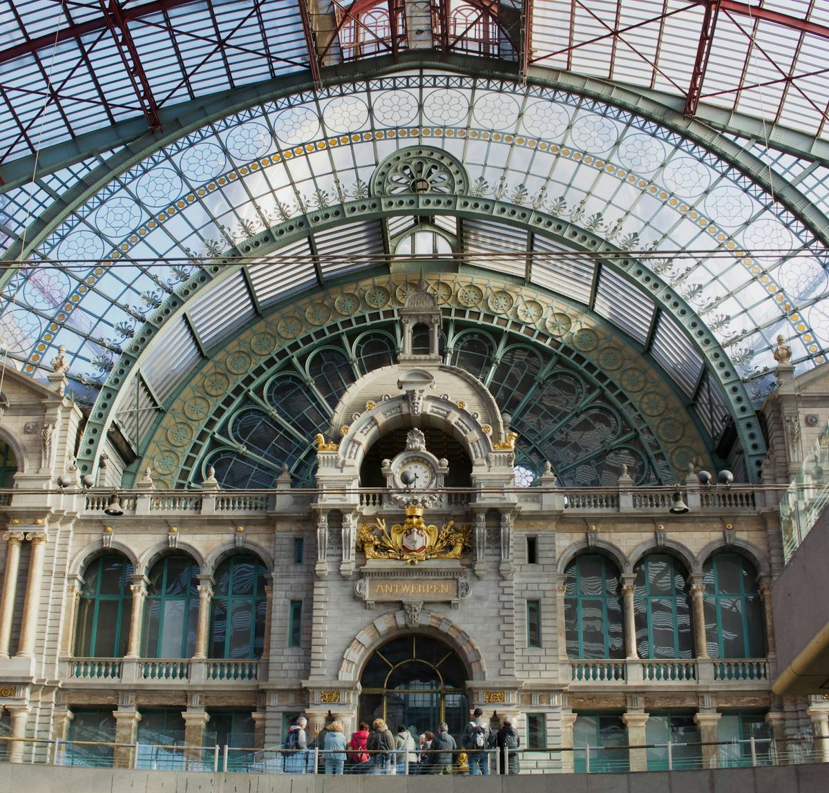 Grand ornate European train station with an arched glass roof