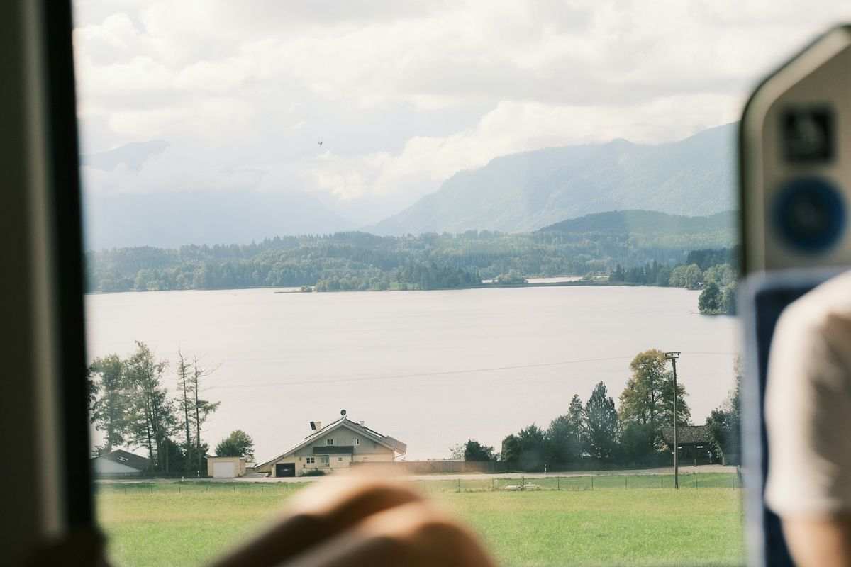 Looking out a train window at a scenic lake