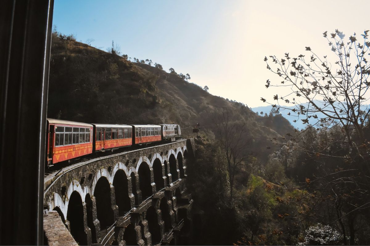Indian train crossing a bridge in the mountains