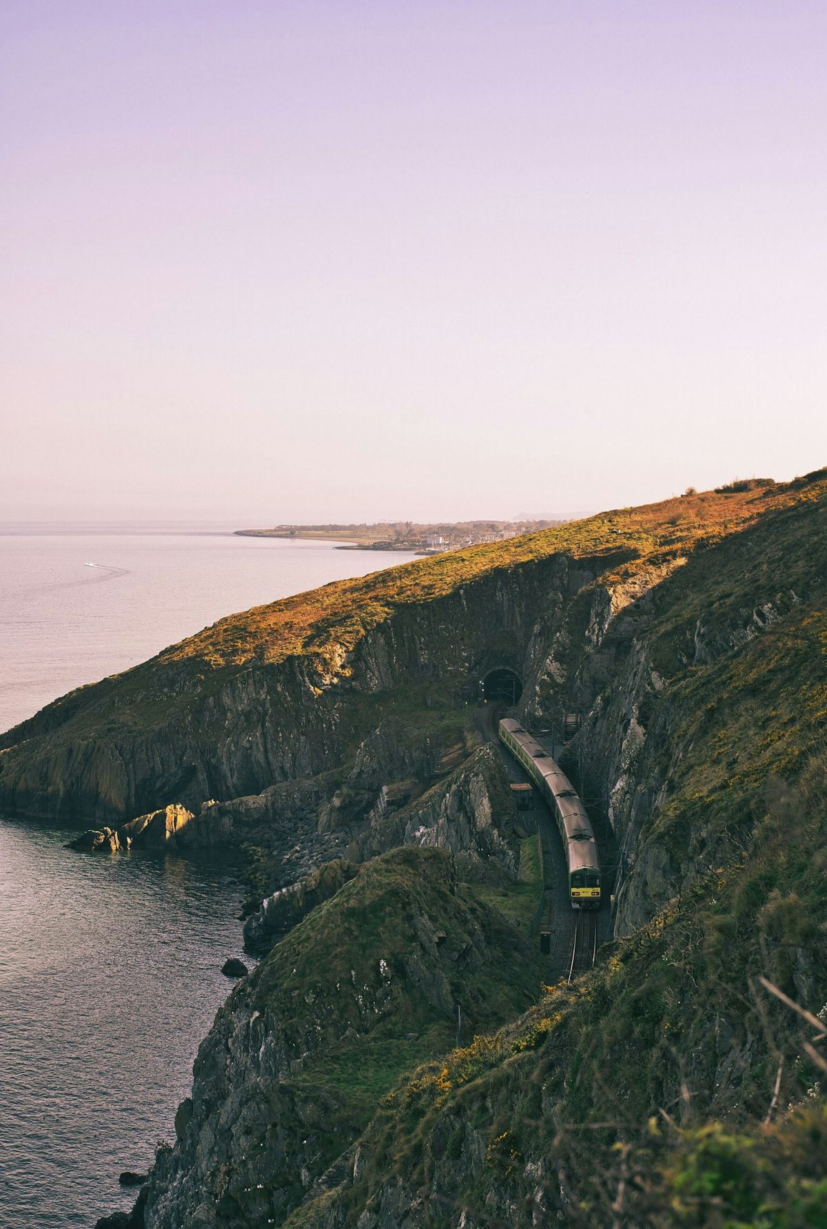 Train traveling along a cliff beside the Irish coast