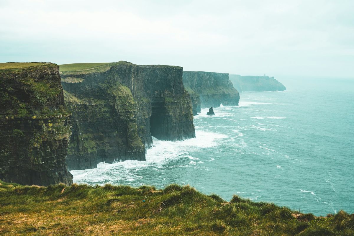Green coastal cliffs of Ireland with crashing waves