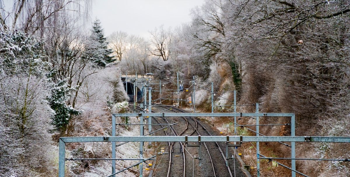 Snow-covered train tracks through Scandinavian winter forest