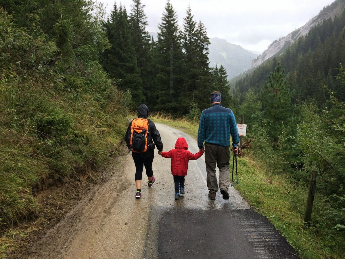 Family with child walking together on a country road