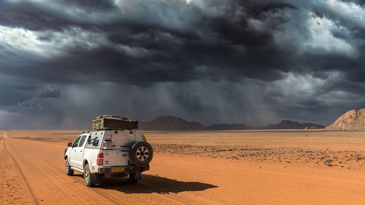 An overland 4x4 vehicle on a dirt road through the Namibian desert