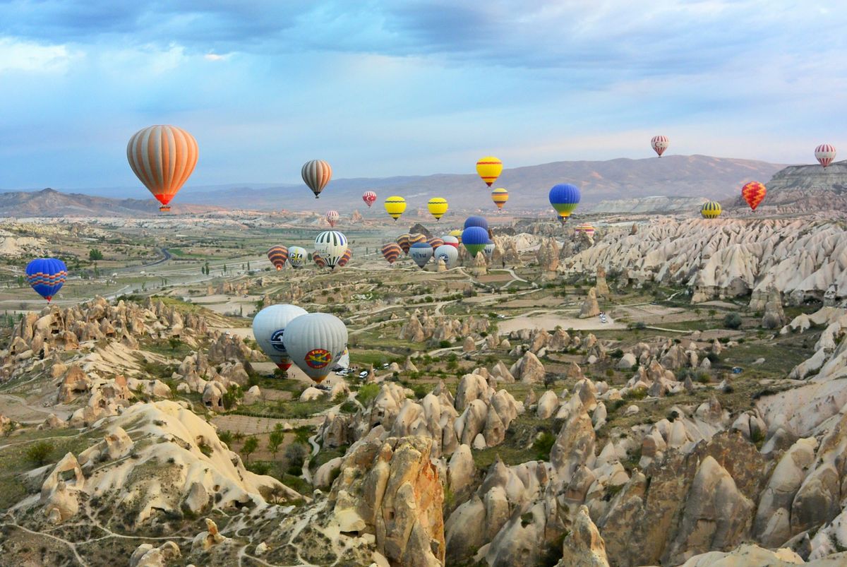Hot air balloons floating above Cappadocia rock formations at sunrise